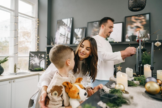 A portrait of happy family in the kitchen decorated for christmas