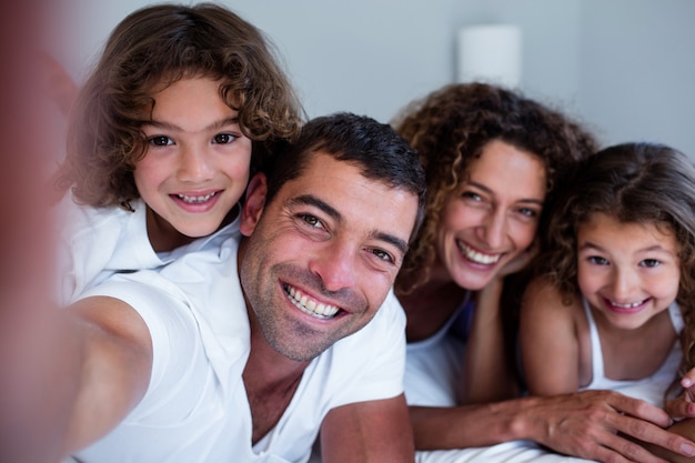 Portrait of happy family lying on bed