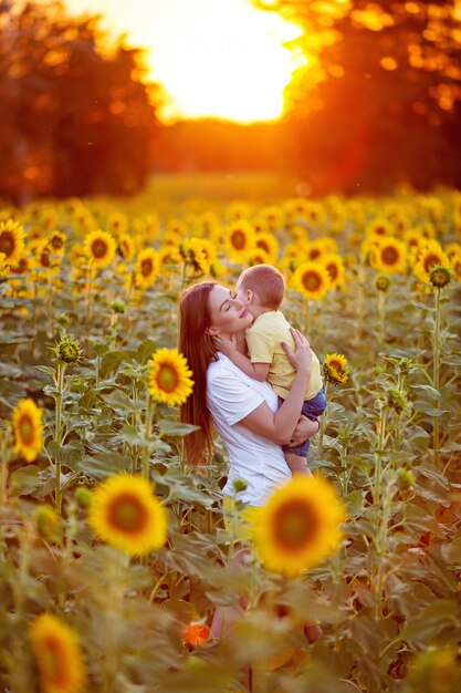 Portrait of a happy family, mom with her son in a field of sunflowers