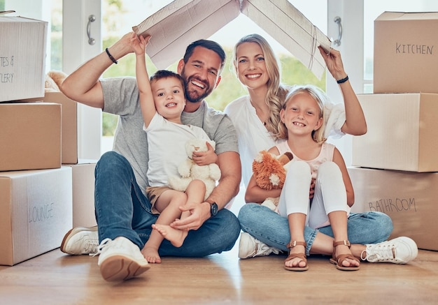 Portrait of happy family new home and cardboard roof for insurance safety and future investment in real estate Moving boxes and happiness mom and dad with kids in house with property mortgage