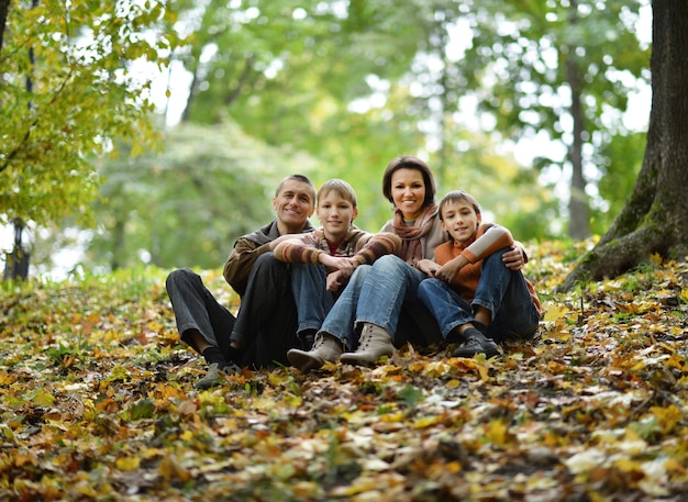 Portrait of happy family relaxing in autumn park