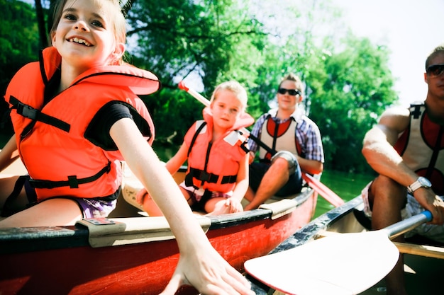 Photo portrait of happy family sitting in boat on lake