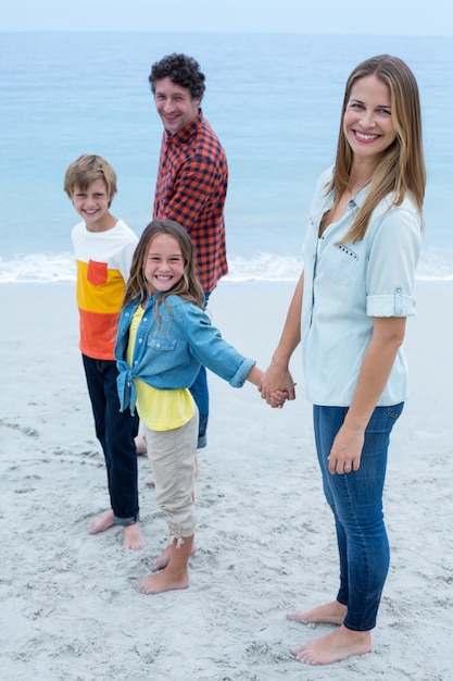 Foto ritratto della famiglia felice che sta alla riva di mare