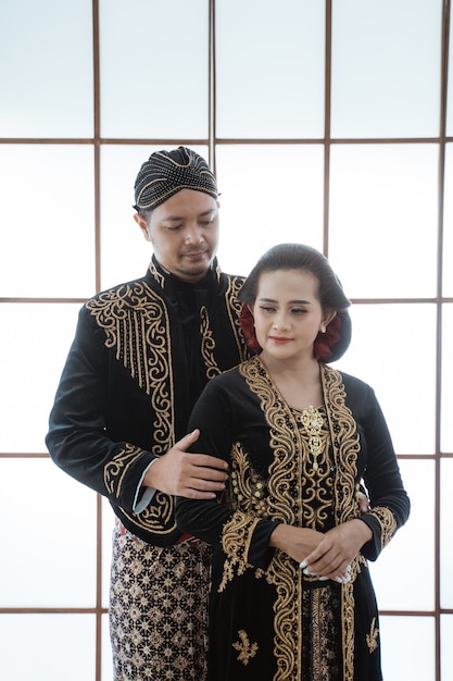 Photo portrait of a happy family wearing traditional javanese clothes