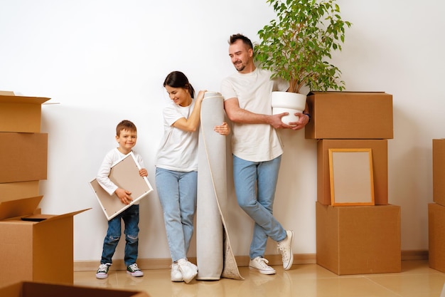 Portrait of happy family with cardboard boxes in new house at moving day