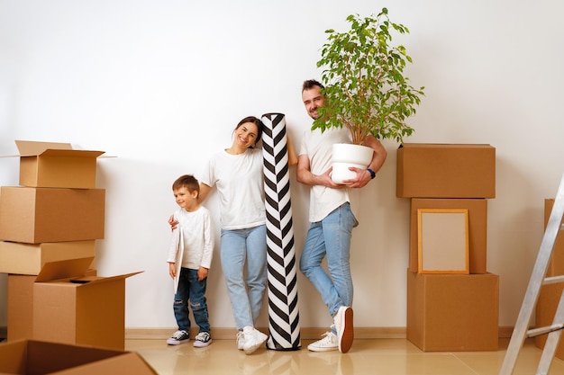 Photo portrait of happy family with cardboard boxes in new house at moving day