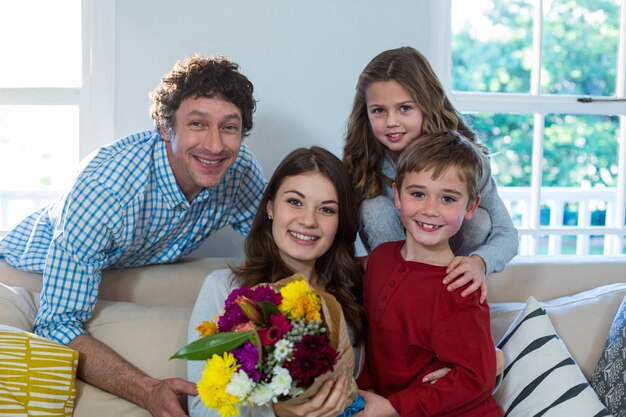 Ritratto di famiglia felice con bouquet di fiori