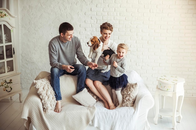 Photo portrait of happy family with pet dog on sofa in living room