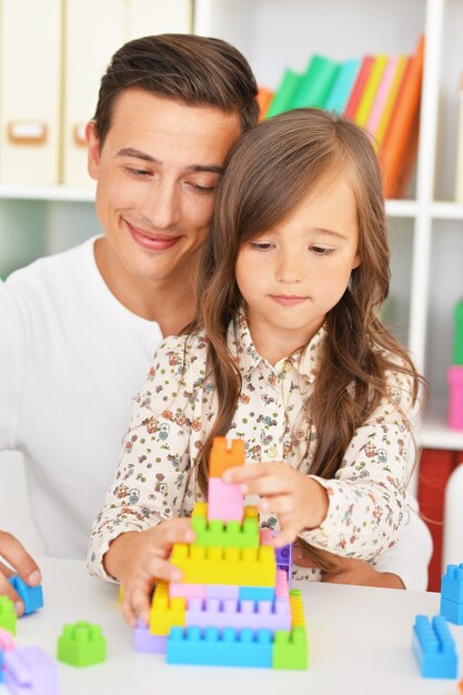 Ritratto di padre e figlia felici che giocano a casa