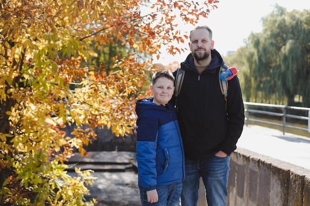 Портрет счастливого отца и сына на открытом воздухе осенью