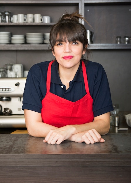 Foto ritratto di felice barista femmina in piedi alla caffetteria alla moda