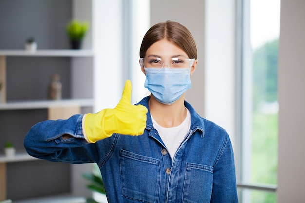 Portrait of happy female cleaner with cleaning equipment in office