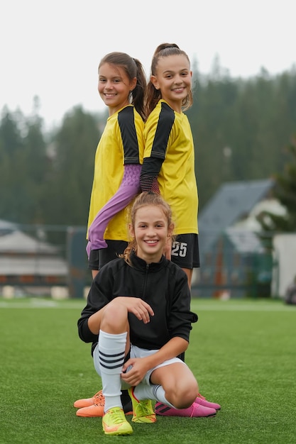 A portrait of a happy female soccer team together on the stadium field