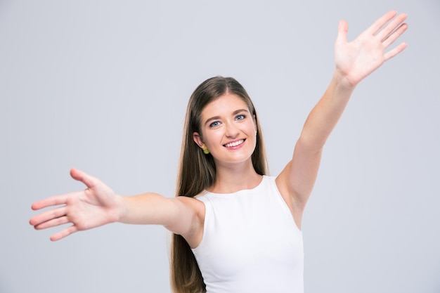 Portrait of a happy female teenager stretching hands to embrace you isolated