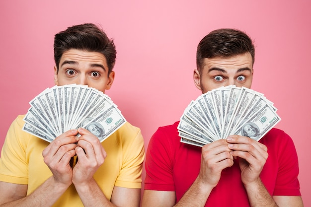 Portrait of a happy friends holding money