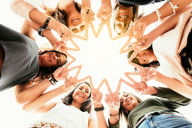 Photo portrait of happy friends joining fingers against clear sky