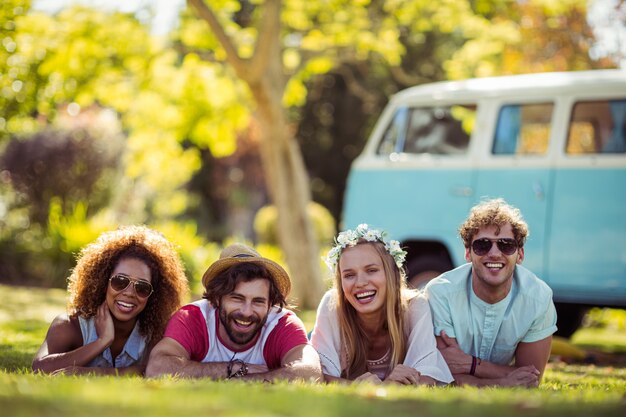 Photo portrait of happy friends lying on grass together