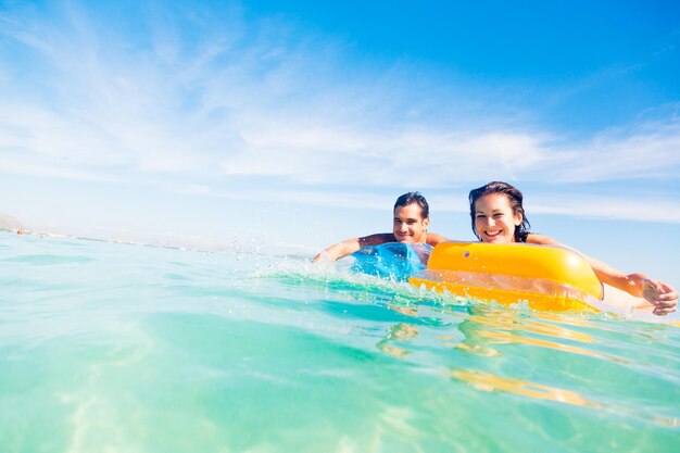 Photo portrait of happy friends relaxing on inflatable rafts over sea