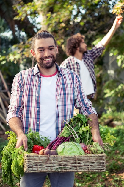 Foto ritratto del giardiniere felice con le verdure al giardino