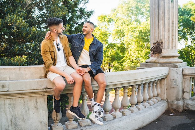 Portrait of happy gay couple spending time together and having a date at the park. Lgbt and love concept.