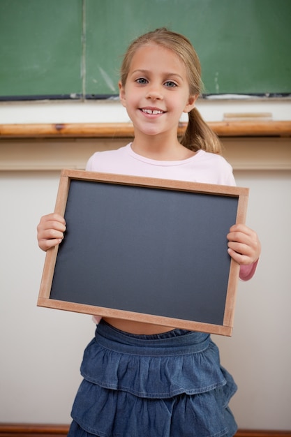 学校のスレートで抱く幸せな女の子の肖像