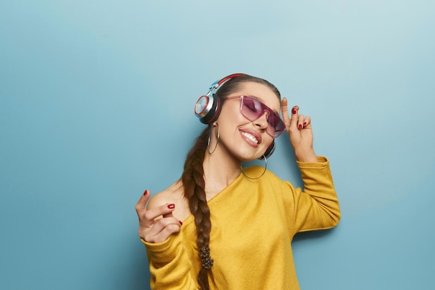 Portrait of a happy girl listening music with wireless headphones from a smartphone