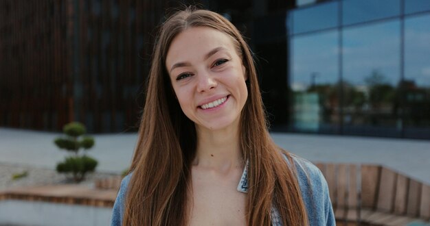 Portrait of happy girl looking to camera Closeup face of beautiful smiling woman with long hair