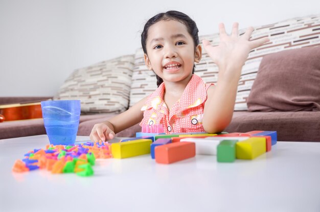 Portrait of happy girl playing with toys at home