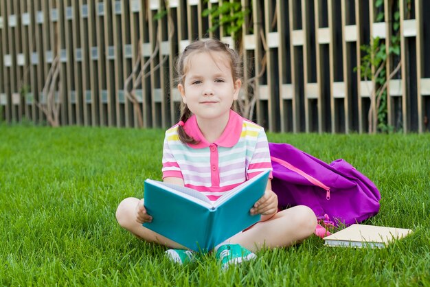 Portrait of happy girl sitting on grass outdoors