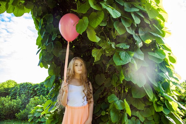 Portrait of happy girl with air balloon enjoying in the park on summertime.