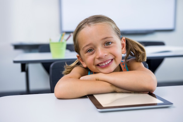 Портрет счастливой девушки с цифровым планшетом в классе