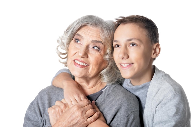 Portrait of happy grandmother and grandson hug and looking at the camera isolated on white background