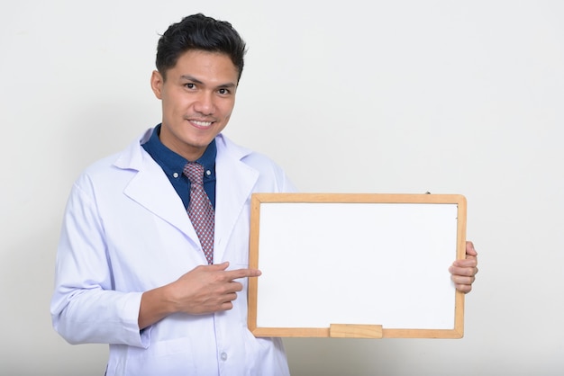 Portrait of happy handsome Asian man doctor smiling