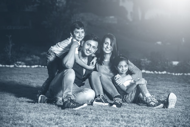Portrait of Happy Indian Asian Family while sitting on Lawn, outdoor