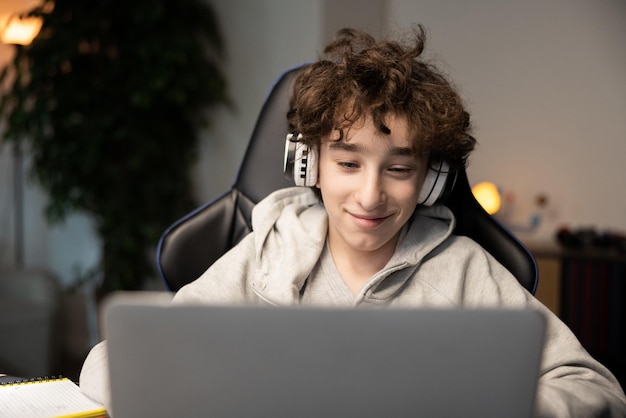 Portrait of happy intelligent young boy smiling at webcam on laptop child has remote lessons