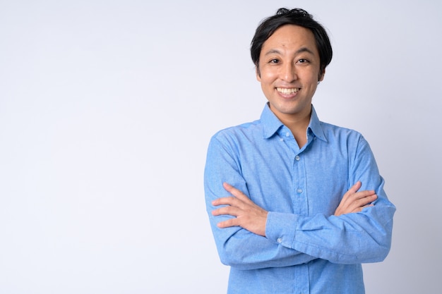 Portrait of happy Japanese businessman smiling with arms crossed