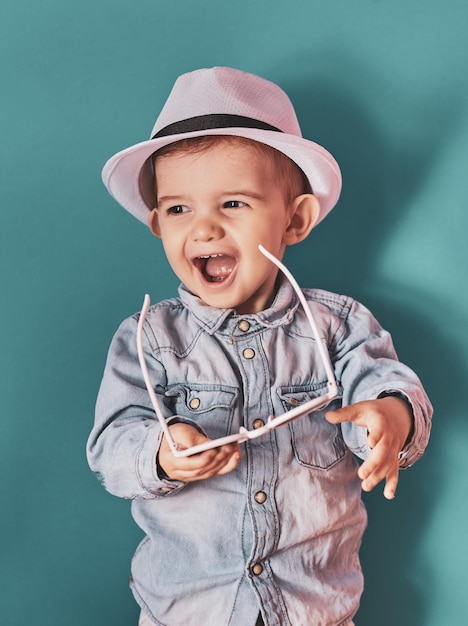 Photo portrait of a happy kid boy in summer fashion stylish isolated on blue background