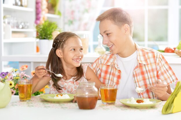 家で朝食をとっている幸せな子供たちの肖像画