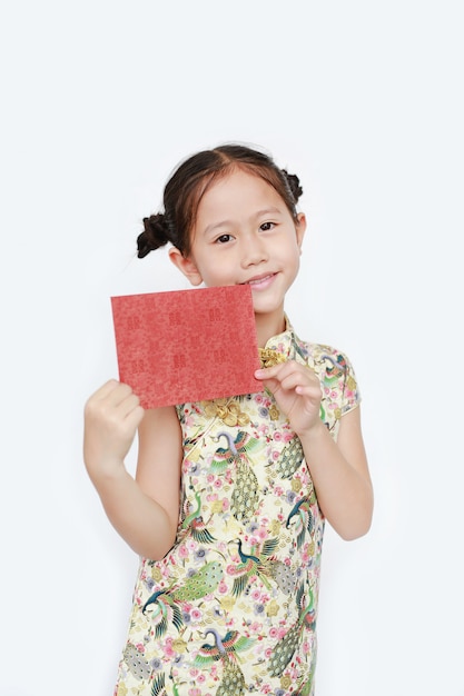 Portrait of happy little Asian girl wearing cheongsam smiling and holding red envelope. Happy Chinese New Year.