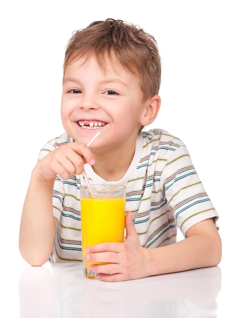 Portrait of happy little boy drinking refreshing orange juice Smiling child with glass of fresh lemonade