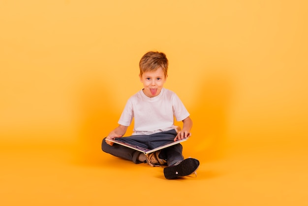 Portrait of happy little boy over yellow background