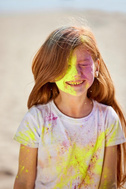 Photo portrait of happy little child girl in holly paints