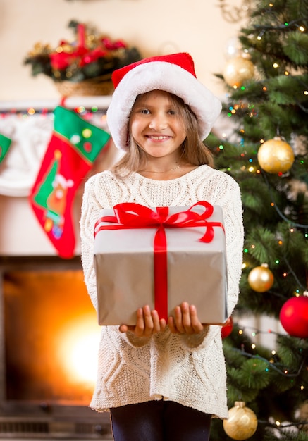 큰 크리스마스 선물 상자를 들고 행복 한 어린 소녀의 초상화