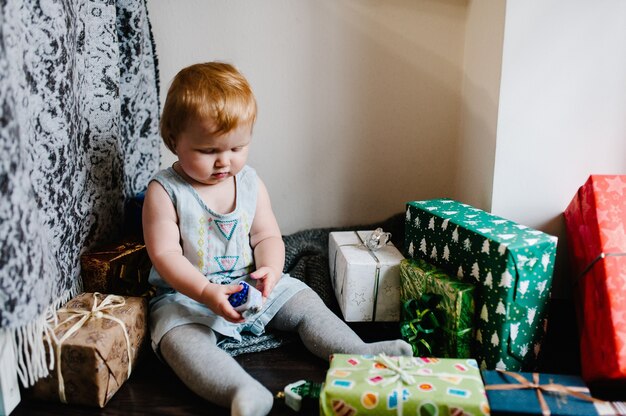 Портрет счастливая маленькая девочка, играющая с игрушками, сидит