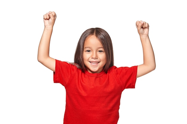 Portrait of a happy little girl with arms raised on air isolated on white background