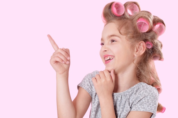 Portrait of happy Little pretty girl   in hair curlers in studio