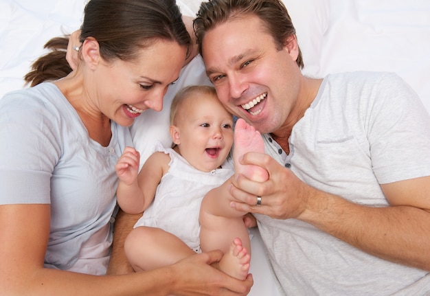 Portrait of a happy loving family playing with baby
