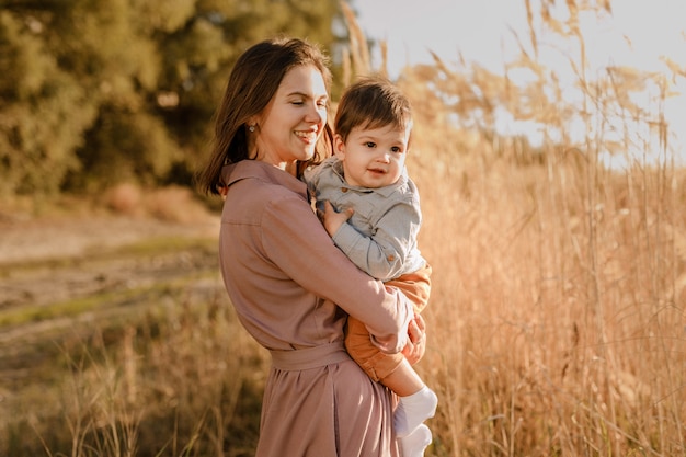 Portrait of happy loving mother and her baby son outdoors.