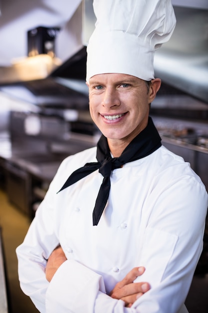 Портрет счастливого мужчины шеф-повара, стоя со скрещенными руками