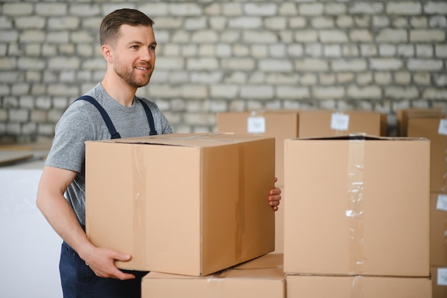 portrait of happy male worker in warehouse standing between shelves
